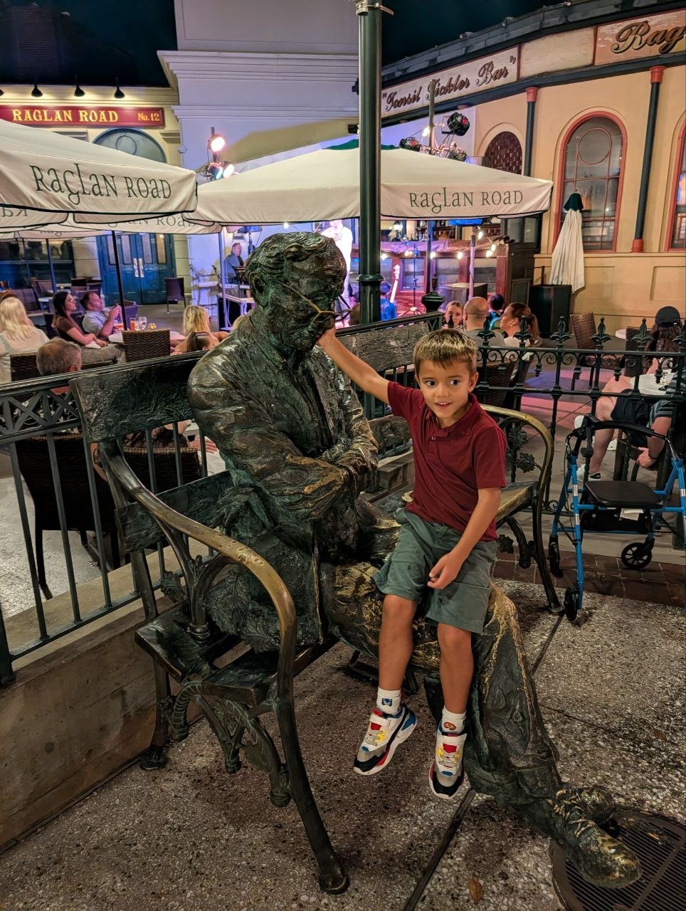 Criança sentada junto à estátua no Raglan Road, em Disney Springs